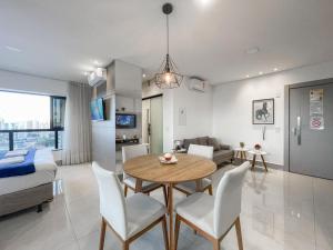 a dining room and living room with a table and chairs at A Melhor Vista de Campo Grande in Campo Grande