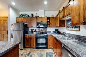 a kitchen with wooden cabinets and a stainless steel refrigerator at Main Street Station #1201 in Breckenridge