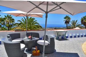 eine Terrasse mit Tisch und Stühlen und einem Sonnenschirm in der Unterkunft Casa Business Finca Alcala in Alcalá