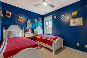Una habitación azul con dos camas y banderas en la pared. en Rehoboth Beach --- 21163 Bayview Rd., en Dewey Beach 17 fotos más