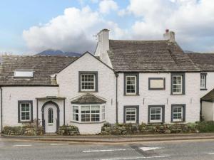 a white house with a mountain in the background at Lakeland View in Keswick