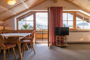 a living room with a table and a television at Haus Anita Sommer-Bergbahnticket-Unlimeted in Oberstdorf