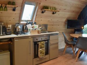 cocina con fogones, fregadero y mesa en Hayfield Haven-Uk40691, en Crowhurst