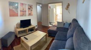 a living room with a blue couch and a tv at Appartement avec terrasse in Santoña