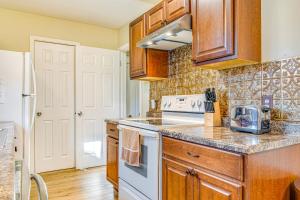 a kitchen with wooden cabinets and a white stove top oven at about 10 Mi to Dtwn Indianapolis Home with Game Room! in Indianapolis +8 photos