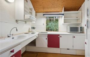 LyneにあるBeautiful Home In Tarm With Wifiの白いキャビネット、シンク、窓付きのキッチン