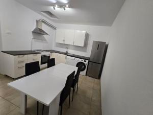 a kitchen with a table and a white table and chairs at Lavitas Premium in Moravče