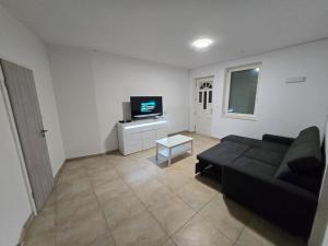 a living room with a black couch and a tv at Lavitas Premium in Moravče