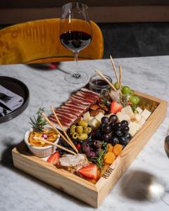 a tray of food on a table with a glass of wine at Pullman Lima Miraflores in Lima