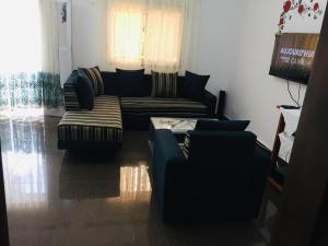 a living room with a couch and two chairs at Résidence D B in Yaoundé