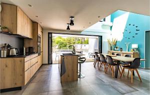 a kitchen and dining room with a table and chairs at Cozy Home In Stjean De Monts in Saint-Jean-de-Monts