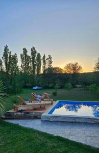 a woman laying on a deck next to a pool at HERMOSA CASA con 4000mts de PARQUE en las SIERRAS DE CORDOBA in José de la Quintana