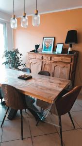 una mesa de madera en una habitación con 2 sillas en Opal'In proche de la plage et des restaurants, en Gravelines 18 fotos más
