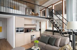 a living room with a couch and a staircase at Eric Vökel Boutique Apartments - Riverfront Suites in Amsterdam +24 photos