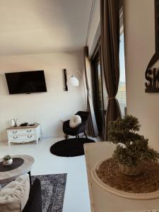 a living room with a tv and a couch and a chair at Sarajevo Skyline Apartment in Sarajevo