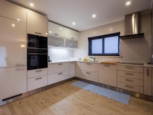a kitchen with white cabinets and a flat screen tv at A Casa do Castelo in Óbidos