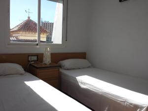 twee bedden in een kamer met een raam bij Benalmadenapartments BBQ Evita Beach Club in Benalmádena +18 foto's