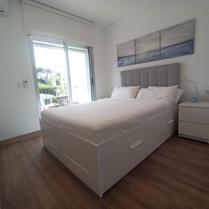 エステポナにあるE1 Desk Private patio Terrace Barbecueの大きなベッドと窓のある白い寝室