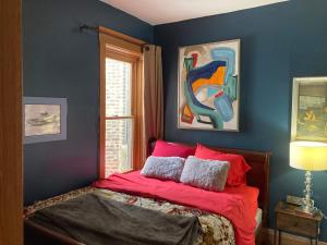 a bedroom with a bed with red sheets and a window at Dorothy's in Chicago