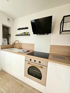 a kitchen with a stove and a tv on the wall at Chez Coco - La maison idéale pour 10 personnes ! in Échenoz-la-Méline +22 photos