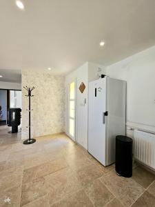 a kitchen with a white refrigerator in a room at Chez Coco - La maison idéale pour 10 personnes ! in Échenoz-la-Méline