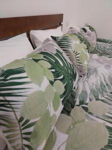 a bed with green and white sheets and plants at BALO'S HOUSE in Bari