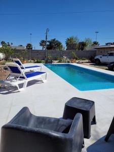 a swimming pool with two chairs and a couch and a table at Amanecer Petit in Miramar