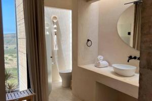 een badkamer met een wastafel, een toilet en een spiegel bij Nubla Residence villa Uno in Ensenada +7 foto's