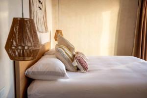 een slaapkamer met een bed met kussens en een lamp bij Nubla Residence villa Uno in Ensenada