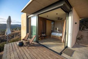 een kamer met een slaapkamer, een bed en een terras bij Nubla Residence villa Uno in Ensenada