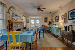 a dining room with blue tables and yellow chairs at Anchor Inn NSB Bed and Breakfast in New Smyrna Beach