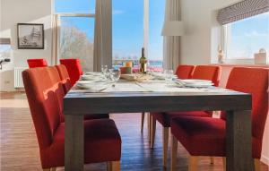 a dining room table with red chairs and a dining room table at Maasvilla - Amfibie - 31 in Ohé en Laak