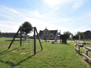 an empty park with swings in the grass at Gutshofblick XL in Hanshagen