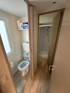 Un pequeño baño con inodoro y ventana. en Mobile home Maris, en Biograd na Moru 14 fotos más