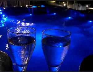 two glasses of water sitting next to a swimming pool at La St Hubsphair in Saint-Hubert