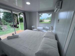 a bedroom with a large white bed and a window at Cautiva Sleep Inn in Guácimo
