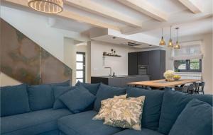 a blue couch in a living room with a kitchen at 5 Bedroom Nice Home In Manjadvorci in Manjadvorci