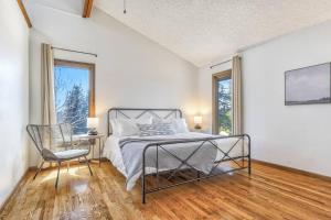a bedroom with a bed and a chair and windows at Private Villa-72 Acres-Hot Tub-Views-USAFA in Colorado Springs