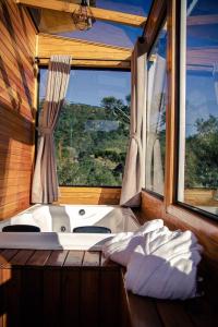 a bath tub in a room with a window at Blue Sunset in Urubici