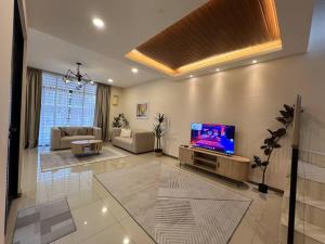 a living room with a flat screen tv on a wall at RUMAH SAUJANA KLIA by IMPIAN HOMESTAY in Sepang