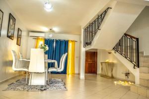 a living room with a table and chairs and a staircase at Private Garden Villa Almadies-Ngor 3 bedrooms wifi in Dakar