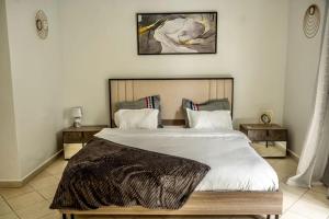 a bedroom with a large bed with a blanket on it at Private Garden Villa Almadies-Ngor 3 bedrooms wifi in Dakar +16 photos