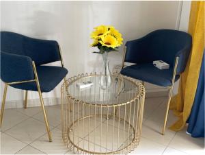 two chairs and a vase with a yellow flower on a table at Private Garden Villa Almadies-Ngor 3 bedrooms wifi in Dakar