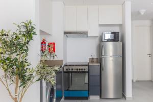 a kitchen with a stove and a refrigerator at Sahab - Urban Living 1BR by HA in Sharjah +15 photos