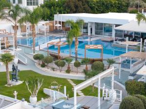 Una vista aérea de la piscina de un resort con palmeras. en White Luxury Villa, en Hersonissos