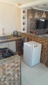 a kitchen with a stove and a white refrigerator at apartamento com Deck e vista mar - Loft Rocha in Rio de Janeiro +17 photos