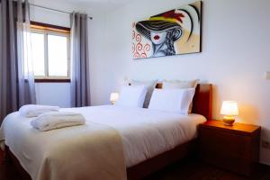 a bedroom with a bed with a painting on the wall at Casa Fundevila Celorico de Basto in Celorico de Basto +26 photos