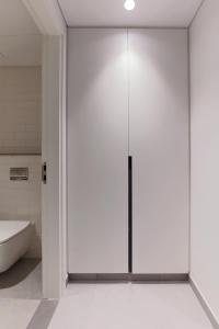 a sliding glass door in a bathroom with a tub at Sahab - Urban Living 1BR by HA in Sharjah