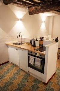 a small kitchen with a sink and a stove at Vivez Bonifacio - Sous le charme in Bonifacio