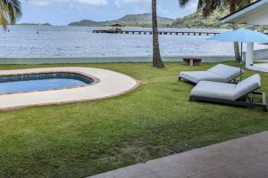 波托韦洛Entire Villa with pool in front of beach!的后院设有游泳池、椅子和遮阳伞
